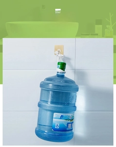 Heavy duty adhesive wall hook shown holding a large water bottle for weight test