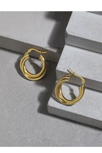 Minimalist gold multi-layer hoop earrings displayed on modern concrete blocks