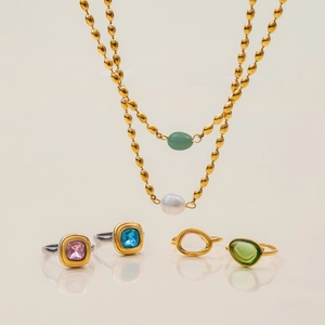 Detalle de collar de doble capa dorado con perlas y piedras preciosas verdes elegantes