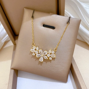 Luxurious gold titanium steel necklace with hollow zircon flowers on beige jewelry cushion