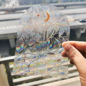 Detail of holographic suncatcher sticker featuring crystal hand and moon design