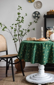 Detailed view of dark green Christmas tablecloth with gold snowflake and bell print patterns