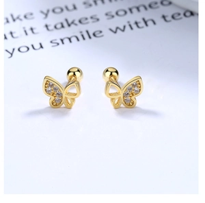 Macro view of gold butterfly stud earrings with zircon stones and screw-back closure