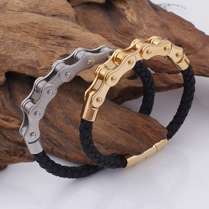Detailansicht von Gold- und Silber-Fahrradketten-Lederarmbändern auf rustikalem Holzgrund