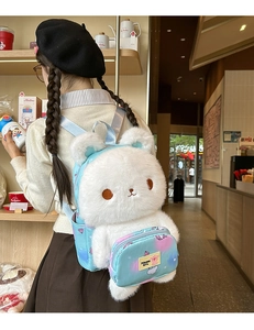 White plush bunny backpack with light blue straps and cartoon pattern front pocket details