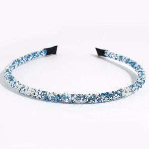 Détail de strass en cristal bleu et blanc sur un serre-tête fin en métal antidérapant