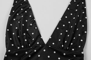 Detail of deep V-neckline with pleated edges on a black and white polka dot summer dress