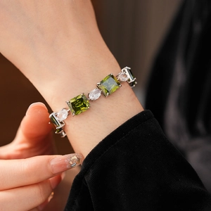 Detail of luxury emerald green square gemstone bracelet with shimmering cubic zirconia