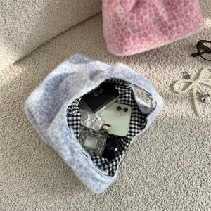 Intérieur spacieux du sac léopard en peluche montrant le rangement du maquillage