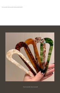 Detail view of five U-shaped acetate hair pins in various marble and tortoiseshell patterns