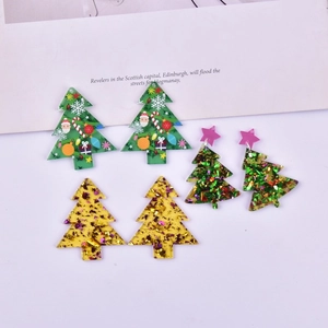 Detailed view of three pairs of acrylic Christmas tree earrings in green and gold glitter