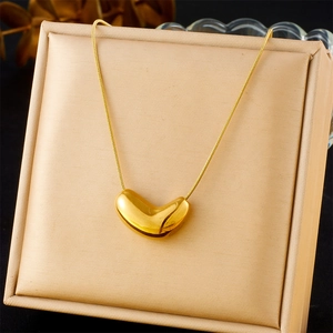 Detail of gold-plated bean pendant on a fine snake chain necklace displayed on a stand