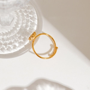 Close-up of gold stainless steel flower ring featuring a 3D floral accent on white backdrop