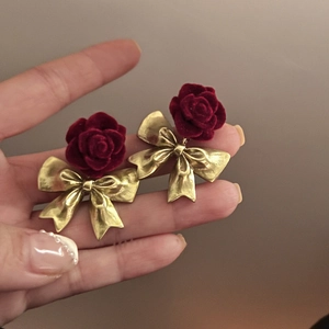 Dettaglio orecchini a rosa rossa floccata con fiocco dorato e perni in argento puro