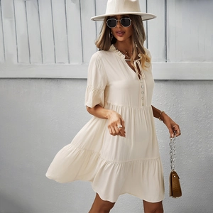 Robe beige élégante à col en V avec ourlet à volants et cordon de serrage sur un mannequin