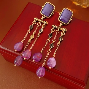 Details von Vintage-Ohrringen mit lila Stein, Goldquasten und schwarzen Perlen