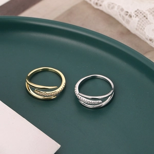 Fashionable multilayer gold and silver rings with zircon stones on green tray