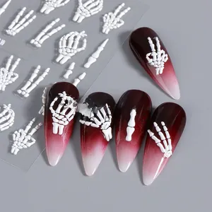 Macro view of 5D embossed white skeleton hand stickers on gradient stiletto nails