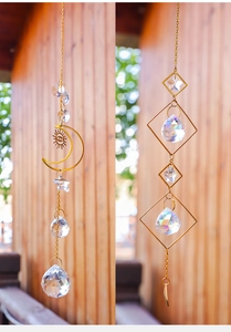 Detail view of golden suncatchers with moon, star, and crystal prisms in natural light