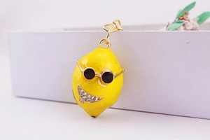 Dettaglio portachiavi a forma di limone giallo con occhiali da sole e strass brillanti