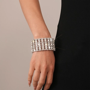 Detail of wide multi-layer silver bracelet with clear rhinestones on model's wrist