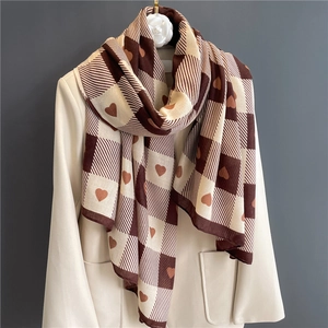 Brown and beige checkerboard cotton scarf with heart pattern draped on a suit jacket