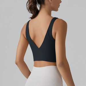 Detail view of back V-cut design on black sports bra and white high-waisted yoga pants