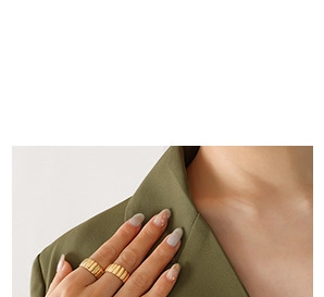 Close-up of gold pleated texture rings layered on finger with modern minimalist style
