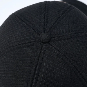 Close-up of black wool baseball cap top showing premium twill texture and button detail