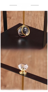 Detail view of the gold-finish weighted glass ball and diamond-style handle on tissue holder