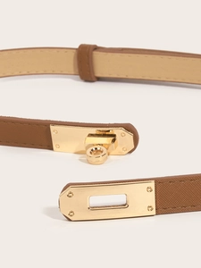 Detailed close-up of brown slim waist belt with golden metal clasp and fine texture