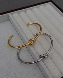Close-up of gold and silver knot cuff bracelets in a jewelry box for luxury gift display