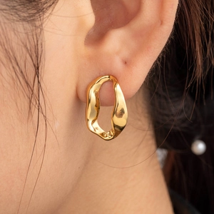 French style gold wave oval earrings in luxury polished stainless steel on model