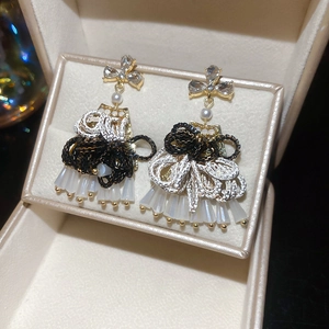 Detail of luxury drop earrings with clover zircon, woven knot and frosted beads