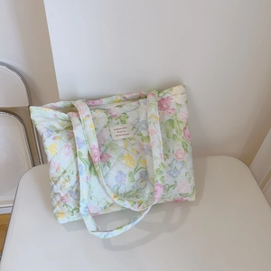 Detailed macro view of floral quilted cotton tote bag with chic French decorative label