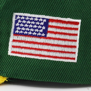 Detailed close-up of premium 3D American flag embroidery on a green cotton baseball cap