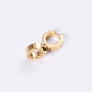 Macro detail of high-polished gold stainless steel ear cuffs with metallic shine