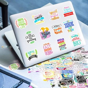 Detail showing motivational vinyl stickers with inspirational quotes on a white laptop