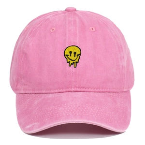 Pink washed cotton baseball cap with yellow melting smiley face embroidery on front