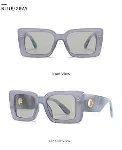 Close-up of blue-gray oversized sunglasses with marble pattern temples and gold ring detail