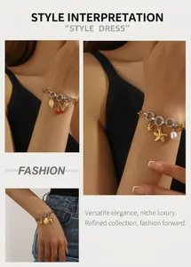 Detail view of gold and silver chain bracelets with cherry and seashell charms