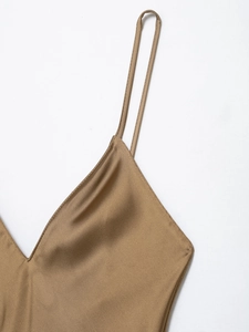 Close-up of golden brown satin dress featuring elegant V-neck and thin spaghetti straps