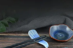 Miniature blue ceramic bowl and chopsticks rest on dark wood for food play scenery