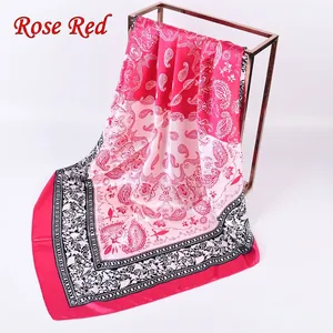 Detail of rose red paisley satin square scarf on a rose gold metal display stand