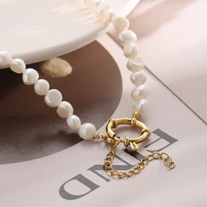 Baroque freshwater pearl necklace with golden OT clasp shown in a lifestyle macro shot