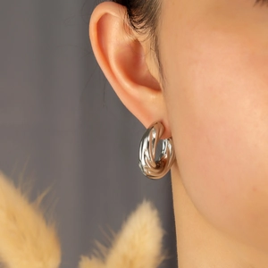 Close-up of a silver twisted moon earring on model with elegant texture