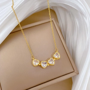 Detail of four gold-plated heart-shaped zircons on a delicate O-chain in a gift box