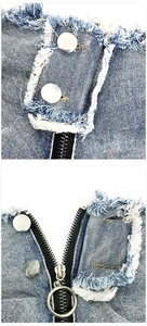 Detail von blauen Denim-Shorts mit Silberknöpfen, Rundreißverschluss und Fransensaum-Textur