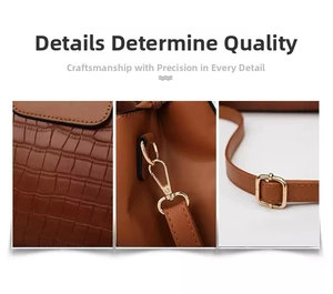 Detail of brown crocodile embossed leather, metal hooks and adjustable strap buckle