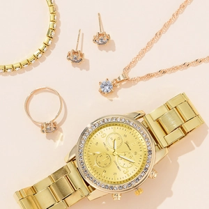 Flat lay of a gold women watch set with matching necklace, earrings, ring and bracelet